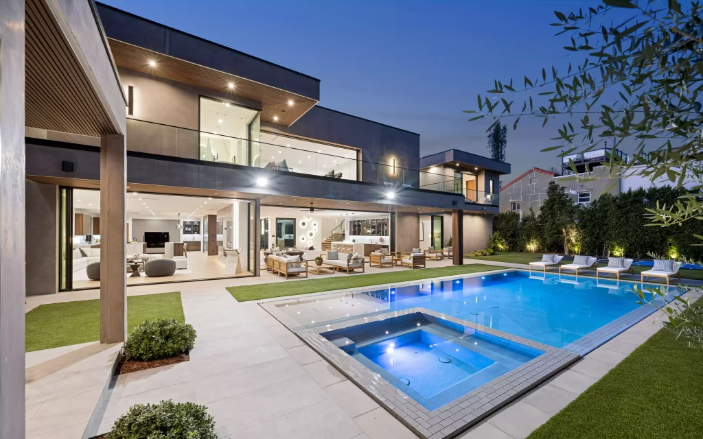 evening view of an outdoor pool located on a deck after remodel