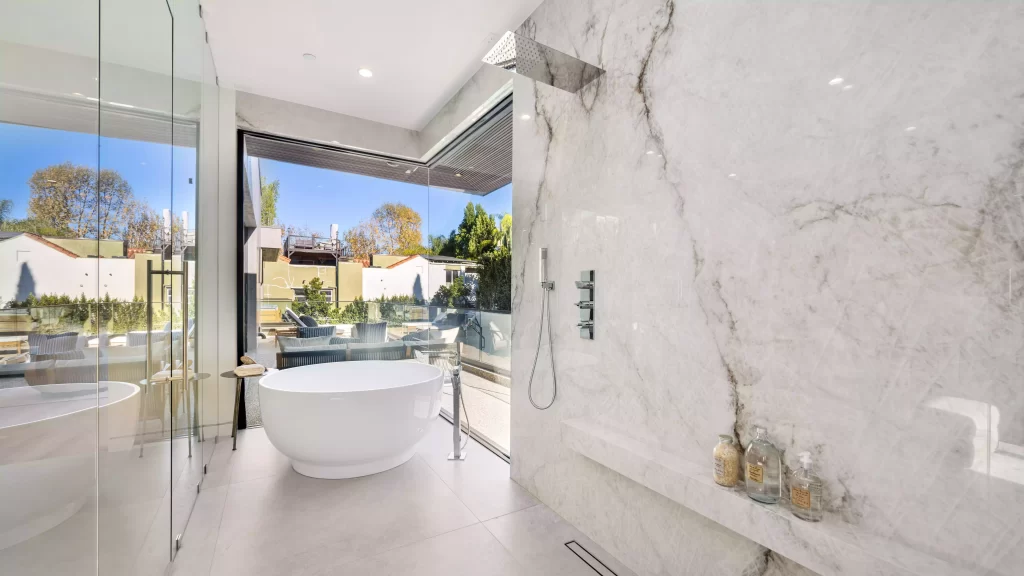 spacious bathroom with a bathtub behind glass pane after renovation